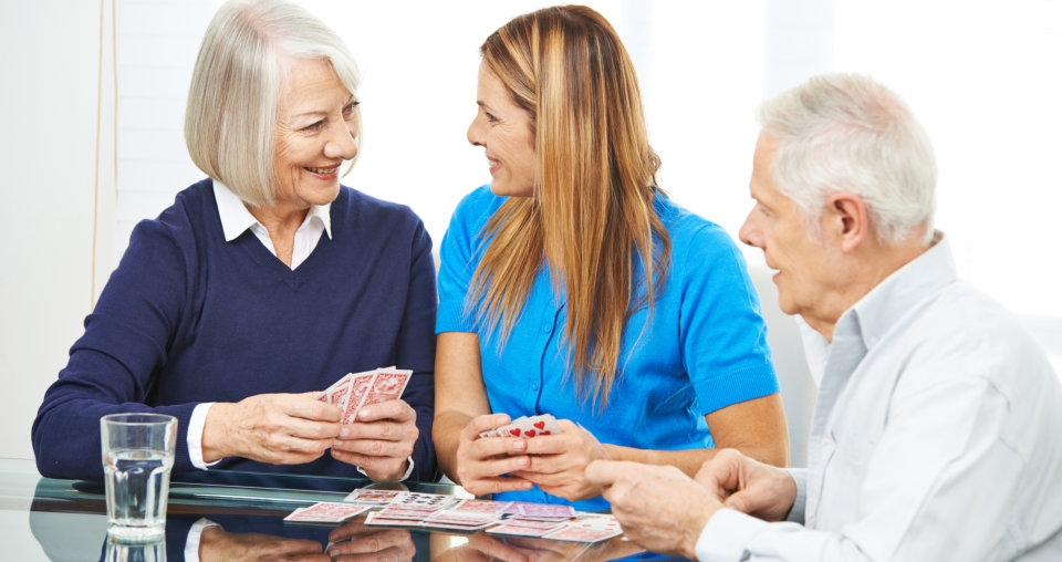 Happy senior people playing cards