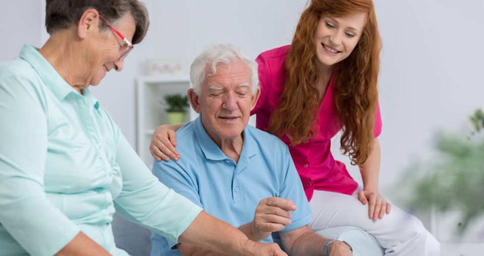 Senior couple and nice carer playing chess